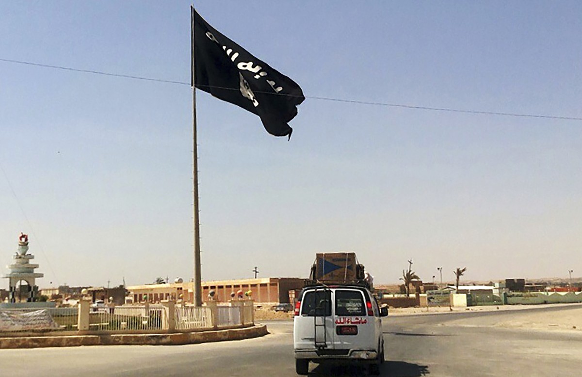 FILE - A motorist passes by a flag of the Islamic State group in central Rawah, 175 miles (281 kilometers) northwest of Baghdad, Iraq, on July 22, 2014. The U.S. Central Command said Wednesday, July 1 ...