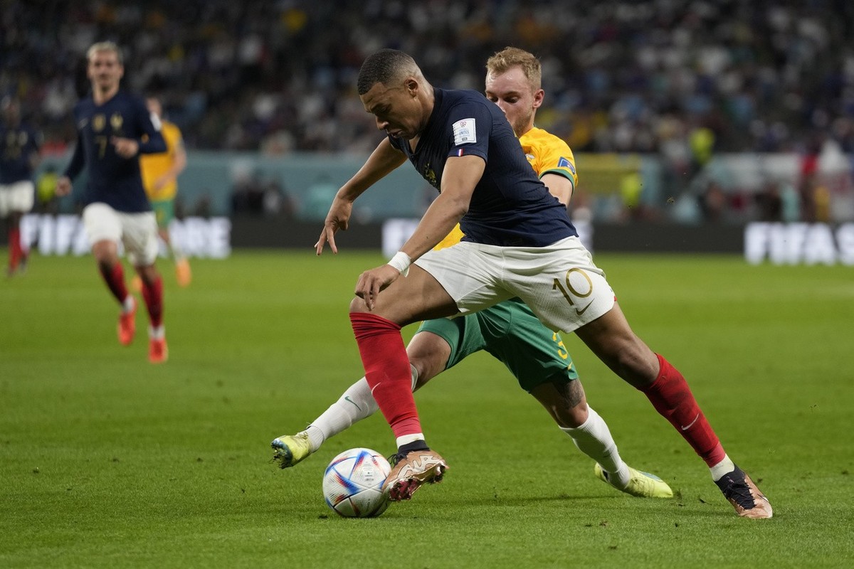 France's Kylian Mbappe, front. And Australia's Nathaniel Atkinson fight for the ball during the World Cup group D soccer match between France and Australia, at the Al Janoub Stadium in Al Wa ...