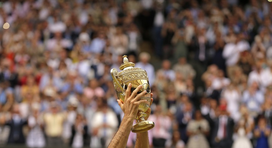 FILE - Switzerland&#039;s Roger Federer celebrates with the trophy after beating Croatia&#039;s Marin Cilic in the Men&#039;s Singles final match on day thirteen at the Wimbledon Tennis Championships  ...