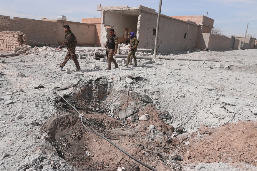 Syrian Democratic Forces (SDF) fighters walk near damaged ground east of Raqqa city, Syria March 26, 2017. REUTERS/Rodi Said