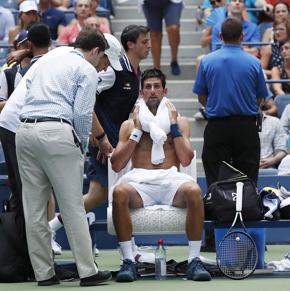 epa06979513 Novak Djokovic of Serbia receives medical treatment as he plays Marton Fucsovics of Hungary during the second day of the US Open Tennis Championships the USTA National Tennis Center in Flu ...