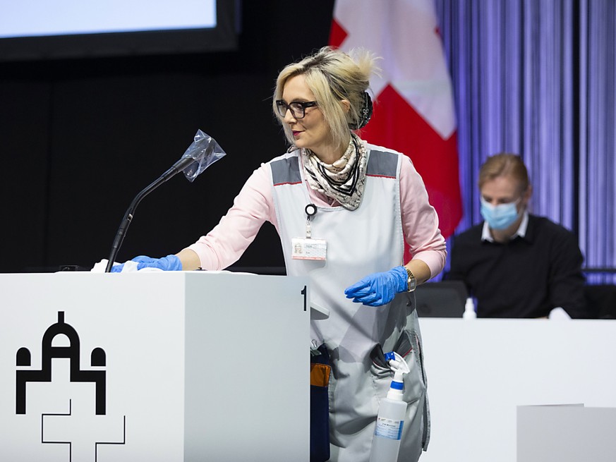 Ana Steko, Mitarbeiterin beim Bundesamt für Bauen und Logistik (BBL), desinfiziert ein Rednerpult während der ausserordentlichen Session der Eidgenössischen Räte in einer Ausstellungshalle der Bernexp ...
