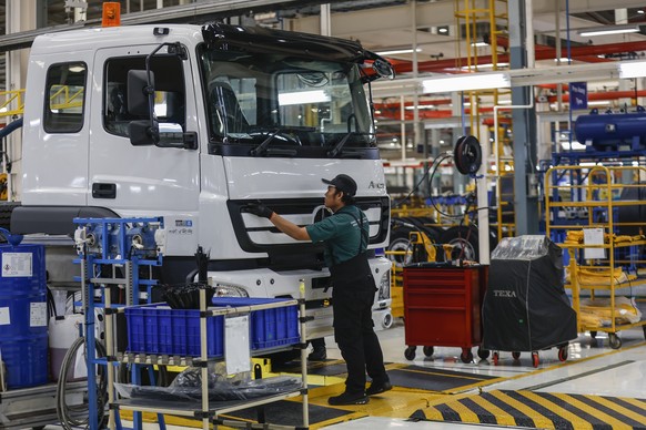 epa12314321 A worker assemble parts of Mercedes trucks during the visit of the German Foreign Minister Johann Wadephul at the Daimler Truck factory in Cikarang, West Java Province, Indonesia, 21 Augus ...