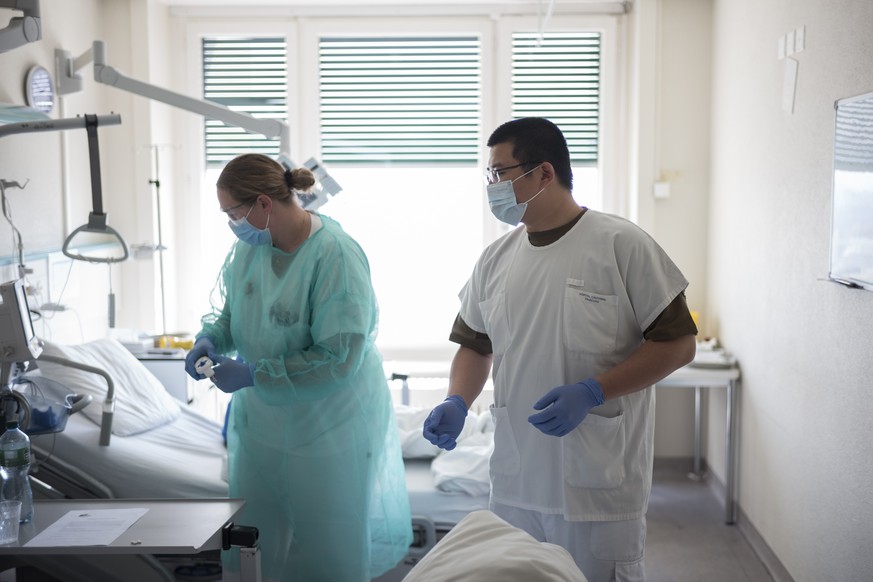 Soldat Liu Kelun, rechts, kuemmert sich zusammen mit einer Pflegefachfrau um einen Covid-19 Patienten, im Freiburger Spital (HFR), am Mittwoch, 8. April 2020 in Freiburg. Fuenfzig Spital- und Sanitaet ...