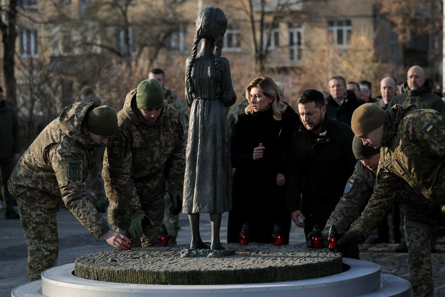 epaselect epa10993851 President of Ukraine Volodymyr Zelensky (2-R) and his wife Olena Zelenska (3-R) place candles at the child statue titled &#039;Bitter Memory of Childhood&#039; by Petro Drozdowsk ...