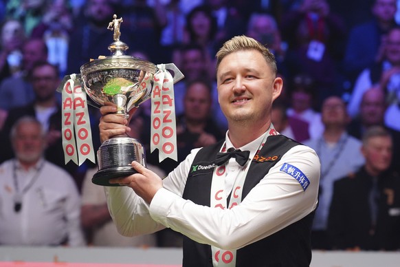 Kyren Wilson celebrates with the trophy after winning the final on day seventeen of the World Snooker Championship at the Crucible Theatre, Sheffield, England, Monday May 6, 2024. (Mike Egerton/PA via ...