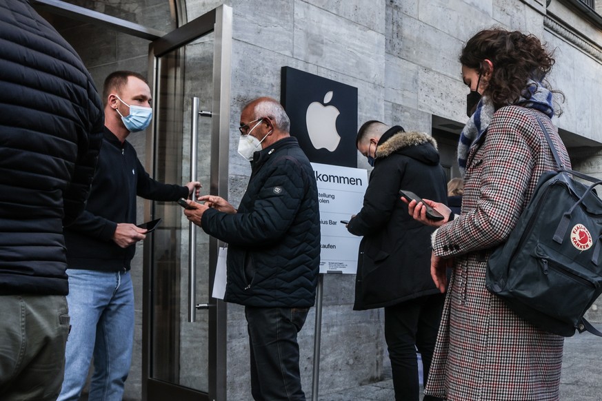 epa09605255 Black Friday shoppers queue outside an Apple store on Kurfuerstendamm street in Berlin, Germany, 26 November 2021. Black Friday is the Friday following Thanksgiving in the United States. T ...