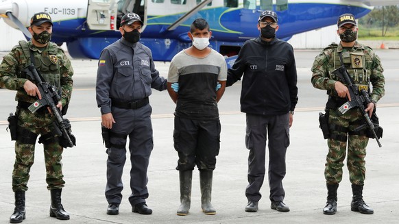 epa08494675 Members of the Armed Forces pose together with the member of the Mobile Column Dagoberto Ramos detained, in Bogota, Colombia, 18 June 2020. In the last hours, members of the National Army, ...