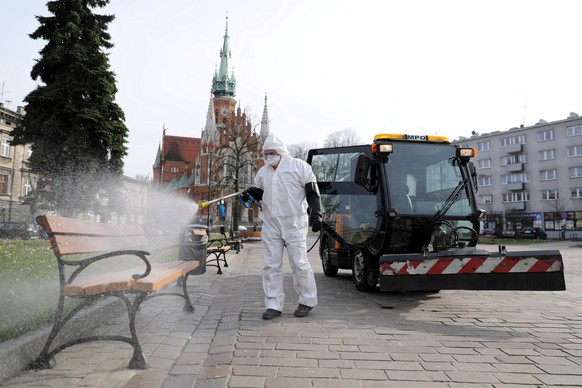 epa08324463 A worker wearing a protective suit disinfects streets as a precaution against the spread of the coronavirus Covid-19 in Krakow, southeastern Poland, 26 March 2020. The number of confirmed  ...