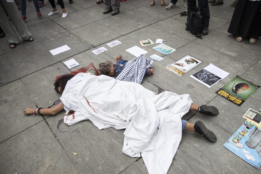 Eine Demonstrantin liegt während der Kundgebung am Boden.