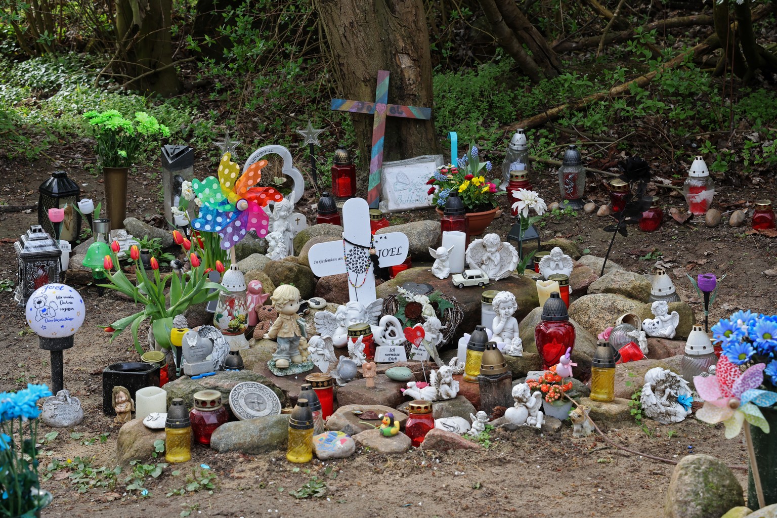 ARCHIV - 04.04.2024, Mecklenburg-Vorpommern, Pragsdorf: Kreuze, Figuren, Kerzen und Blumen stehen an der Stelle, wo der sechsj