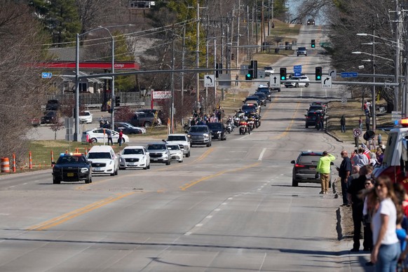 Community members look on during a procession for Iowa National Guard members Maj. Jeffrey O'Brien, of Waukee, Iowa, and Sgt. Declan Coady, of West Des Moines, Iowa, who both died when a drone hi ...