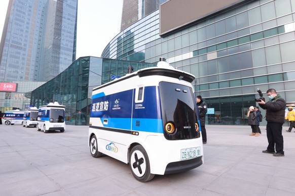 BEIJING, CHINA - JANUARY 16: A citizen takes photos of unmanned patrol vehicles during their road test on January 16, 2024 in Beijing, China. The first batch of unmanned patrol vehicles in China begin ...