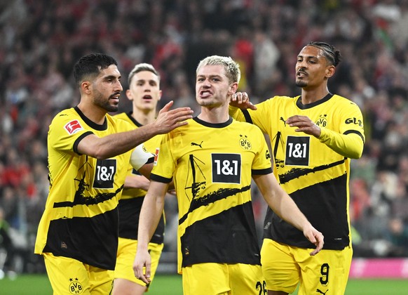 30.03.2024, Bayern, München: Fußball: Bundesliga, Bayern München - Borussia Dortmund, 27. Spieltag, Allianz Arena. Die Spieler von Dortmund mit Torschütze Dortmunds Julian Ryerson (M) jubeln über das  ...