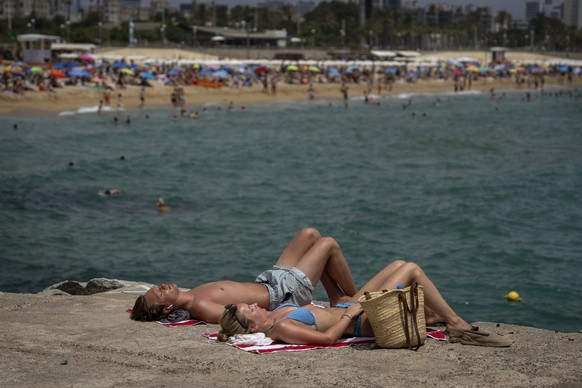 People sunbathing on a beach in Barcelona, Spain, Sunday, June 19, 2022. Temperatures in Western Europe rose above 40 Cs (104 F) in France and Spain, and highs of 38 C (100.4 F) in Germany and 36 C in ...