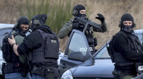Police officers prepare for an operation close to a road where two police officers were shot during a traffic stop near Kusel, Germany, Monday, Jan. 31, 2022. Police say two officers have been shot de ...