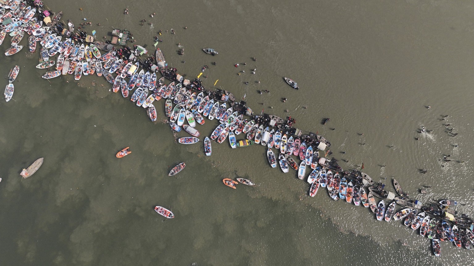 Boats line up the banks as Hindu devotees arrive to take a ritualistic bath in the Sangam, the confluence of three rivers Ganges, the Yamuna and the mythical Saraswati, during Makar Sankranti festival ...