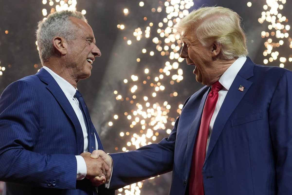 Republican presidential nominee former President Donald Trump shakes hands with Independent presidential candidate Robert F. Kennedy Jr. at a campaign rally at the Desert Diamond Arena, Friday, Aug. 2 ...