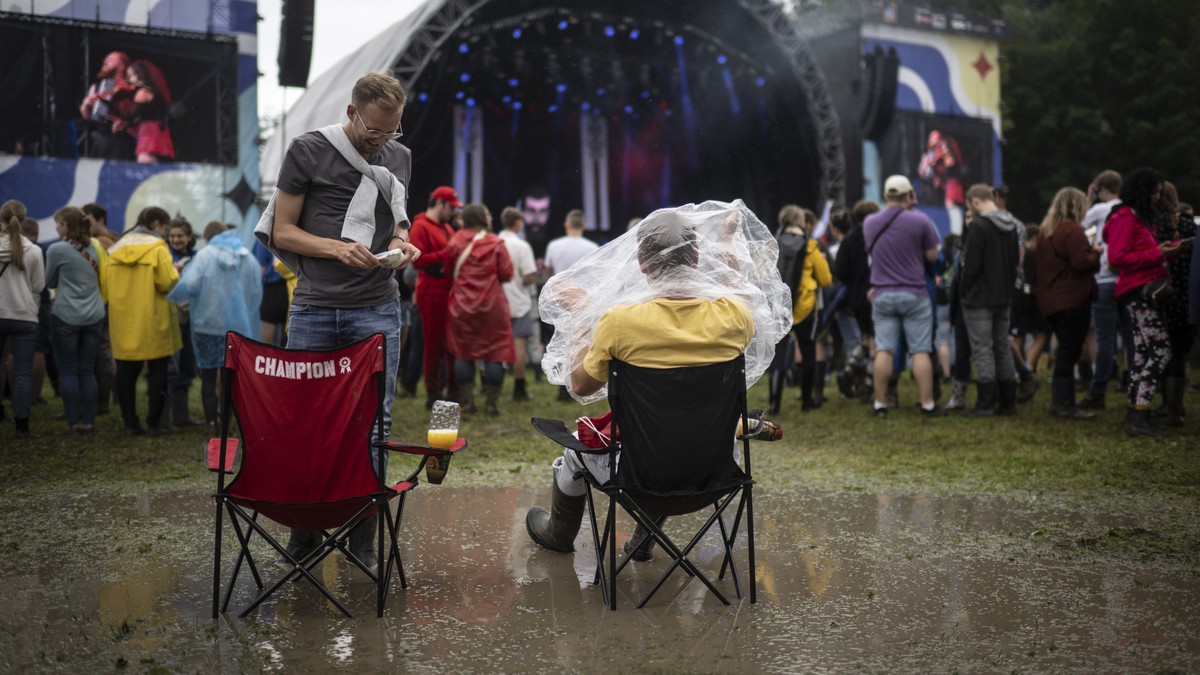Spectators shelter themselves from the rain in front of the main stage at the Openair St. Gallen, on Friday, July 1, 2022, in St. Gallen. The festival will take place until Sunday, July 3, 2022. (KEYS ...