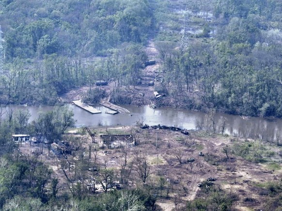 In this handout photo provided by the Ukraine Armed Forces on Thursday, May 12, 2022, a ruined pontoon crossing with dozens of destroyed or damaged Russian armored vehicles on both banks of Siverskyi  ...