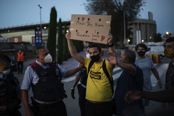 Police remove Barcelona fans from the Camp Nou stadium during a protest against the club's president Josep Maria Bartomeu, in Barcelona, Spain, Wednesday, Aug. 26, 2020. Lionel Messi has told Bar ...
