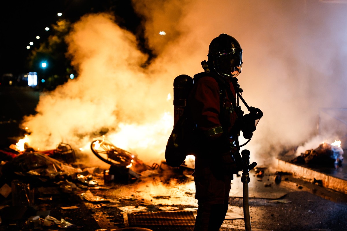 epa13314527 A French firefighter responds to a street barricade burns as clashes between riot police and demonstrators continue for the second day during nationwide protests against the high cost of l ...