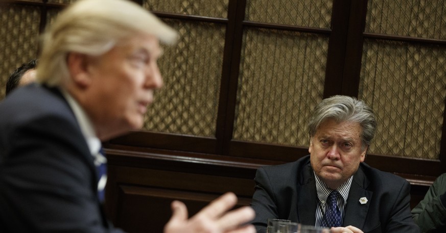 White House Chief Strategist Steve Bannon listens at right as President Donald Trump speaks during a meeting on cyber security in the Roosevelt Room of the White House in Washington, Tuesday, Jan. 31, ...