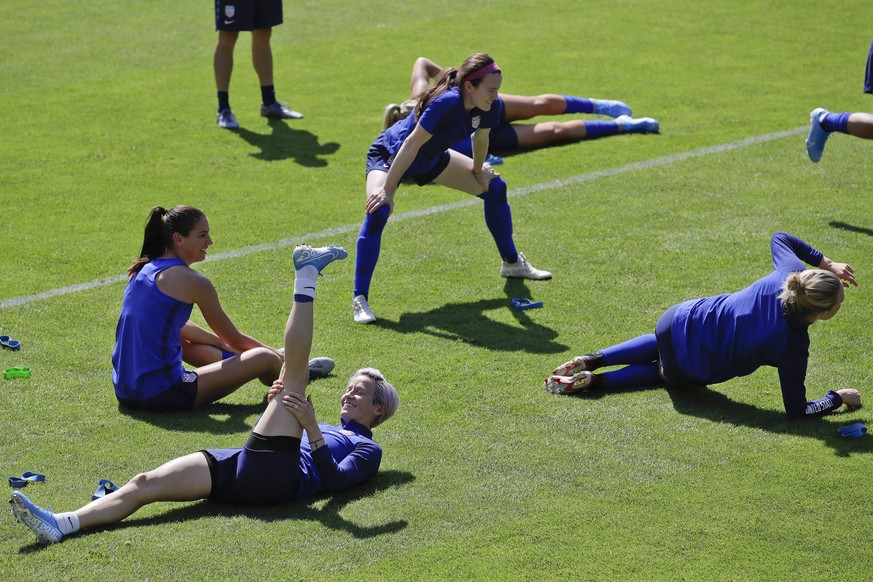 United States&#039; players from left, Megan Rapinoe, Alex Morgan, and Rose Lavelle warm up during a training session at the Gymnase Parc des Sports in Limonest, outside Lyon, France, a day before the ...