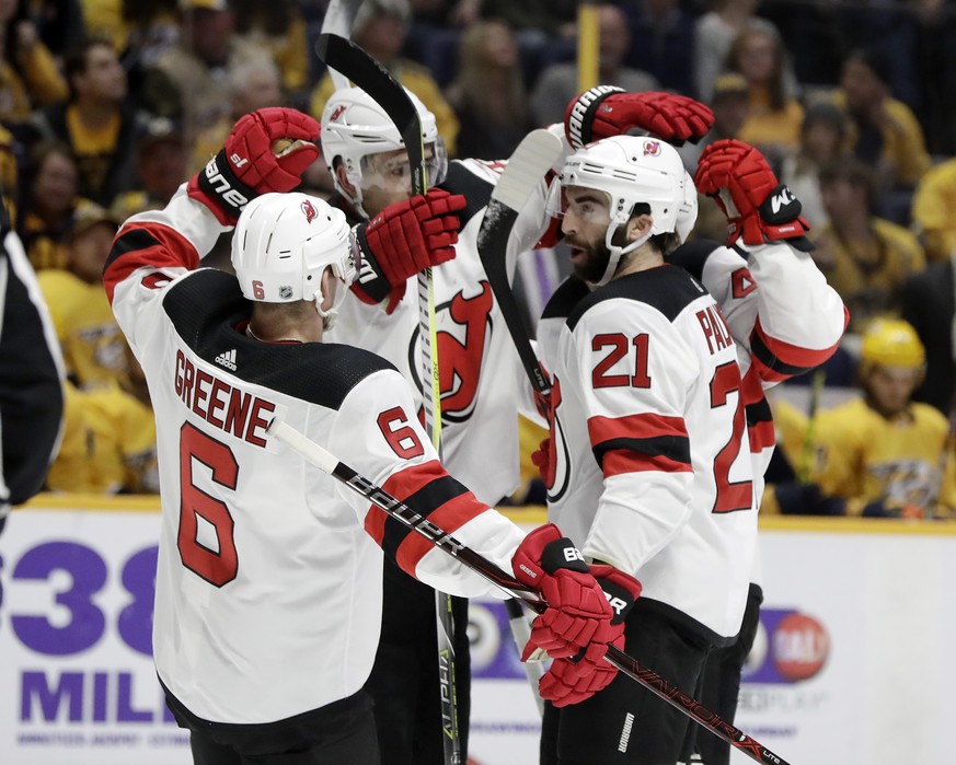 New Jersey Devils defenseman Andy Greene (6) and right wing Kyle Palmieri (21) celebrate a goal by Sami Vatanen, back right, against the Nashville Predators in the first period of an NHL hockey game S ...