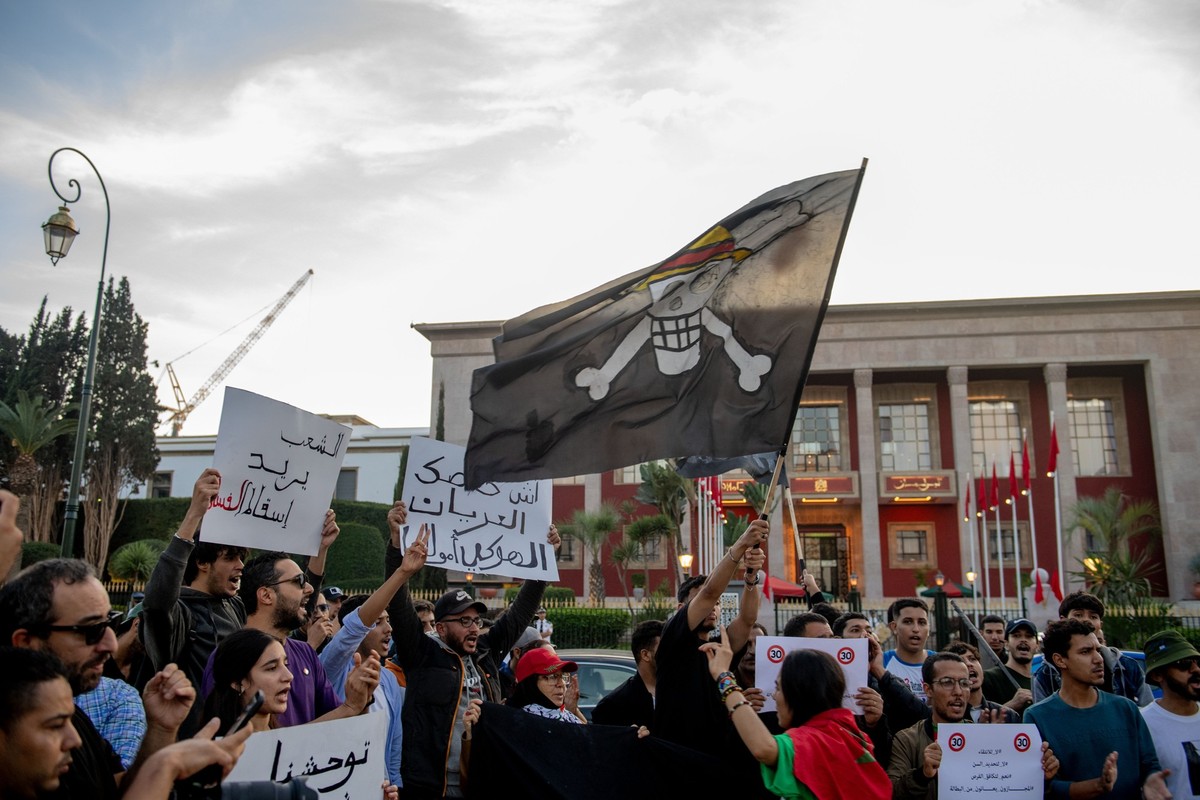 epa12463194 Demonstrators hold up signs and wave a 'Jolly Roger' flag during a protest organized by the self-styled 'GenZ 212' collective in Rabat, Morocco, 18 October 2025. The gr ...