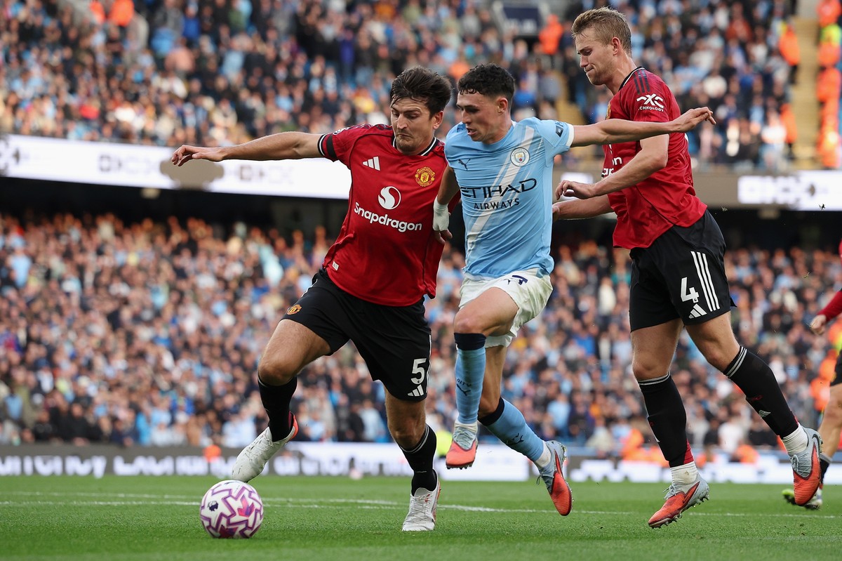 epa12377076 Manchester City's Phil Foden (C) in action against Manchester United's Harry Maguire (L) and Matthijs de Ligt (R) during the English Premier League soccer match between Mancheste ...