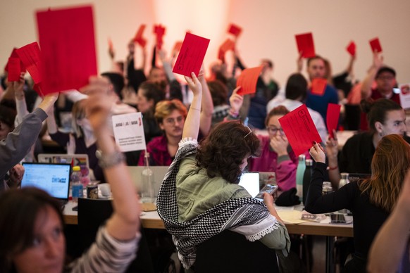 Delegierte stimmen ab zu den Resolution zum Nahen Osten, darunter eine Delegierte mit Kufiya (Palaestinensertuch), am Parteitag der SP Schweiz, am Sonntag, 27. Oktober 2024, in Davos. (KEYSTONE/Gian E ...