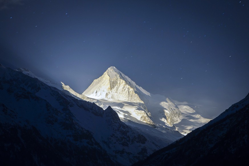 Dent Blanche mountain is illuminated with pyrotechnics during the 13 stars on the summit event, in &quot;Les Hauderes&quot; Val d&#039;Herens, Switzerland, Wednesday, March 18, 2015. The 13 stars on t ...