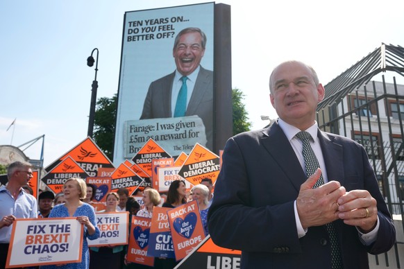 Liberal Democrat Leader Ed Davey stands in front of a TV screen showing Reform UK leader Nigel Farage as he unveils a new national billboard campaign to mark the 10th anniversary of the Brexit referen ...