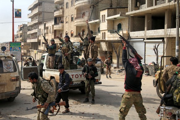 epa06612363 Turkish-backed Free Syrian Army soldiers celebrate after capturing the city of Afrin from Kurdish Popular Protection Units (YPG) forces, northern Syria, 18 March 2018. Turkish President Re ...