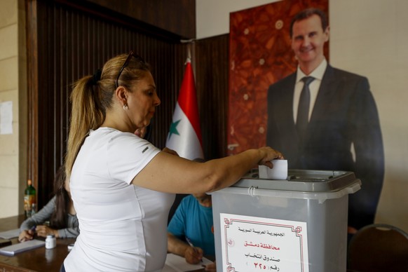 A Syrian woman casts her vote at a polling station during the Syrian parliamentary election in Damascus, Syria, Monday, July 15, 2024. Syrians were voting for members of a new parliament in an electio ...