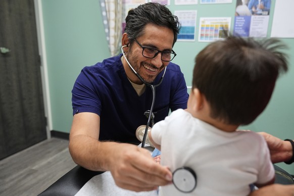 Pediatrician Irving Phillips, left, examines a 16-month-old boy at a CommuniCARE+OLE clinic Thursday, June 26, 2025, in Davis, Calif. (AP Photo/Godofredo A. V�squez)
US Medicaid Immigration States