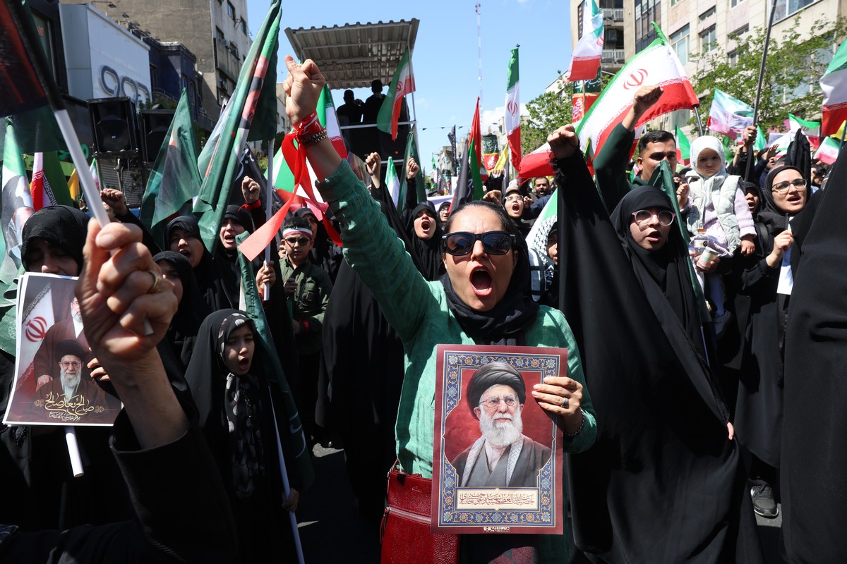 epa12877267 Iranians hold pictures of the late Iranian supreme leader Ayatollah Ali Khamenei as they take part in a rally to commemorate the 40th day of his death anniversary in Tehran, Iran, 09 April ...
