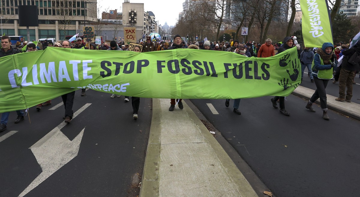 epa11009010 People carry a banner reading 'climate stop fossil fuels' during the annual Big Climate March 2023, in Brussels, Belgium, 03 December 2023. The protest, coinciding with the 2023  ...