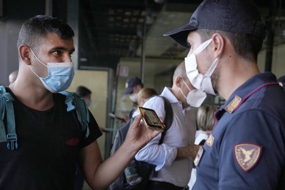 A police officer checks a passenger&#039;s phone at Porta Garibaldi train station, in Milan, Italy, Wednesday, Sept. 2, 2021. Italy&#039;s government vowed to crack down on demonstrators threatening t ...