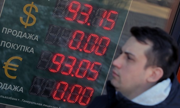 epaselect epa09846034 A man walks past an electronic panel displaying currency exchange rates for US dollar and euro against Russian ruble in Podolsk, outside Moscow, Russia, 24 March 2022. Natural-ga ...