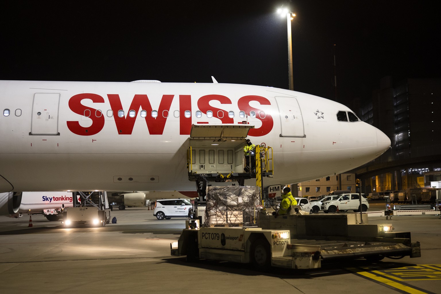 Workers load relief supplies of the Swiss Humanitarian Aid for to the earthquake-hit Turkey onto an airplane at Zurich Airport, on Monday, February 6, 2023 in Zurich, Switzerland. A powerful 7.8 magni ...