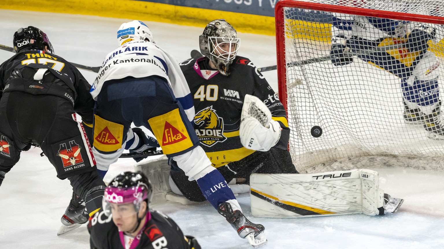 Ajoies Torhueter Tim Wolf, rechts, muss sich zum 0:5 geschlagen geben beim Eishockey-Qualifikationsspiel der National League zwischen dem HC Ajoie und dem EV Zug in der Raiffeisen Arena in Porrentruy, ...