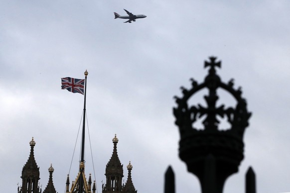 FILE - In this file photo dated Saturday, Dec. 14, 2019, a British flag waves atop of Houses of Parliament as an aircraft approaches the airport in London. After nearly five decades of economic and so ...