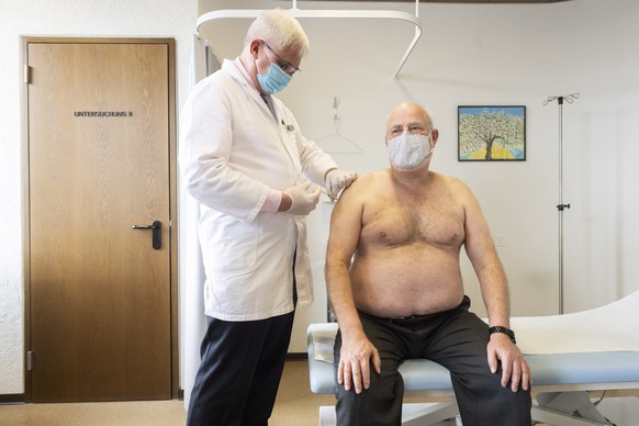 epa08948539 Family doctor Josef Widler (L) vaccinates Hans Koller with the COVID-19 vaccine manufactured by the US biotechnology company Moderna, at his practice in Zurich, Switzerland, 19 January 202 ...