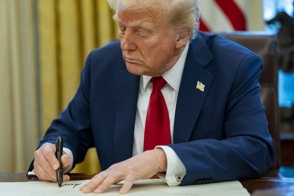 epa11865078 US President Donald Trump signs two executive orders in the Oval Office of the White House in Washington, DC, USA, 30 January 2025. The first order formally commissioned Christopher Rochel ...