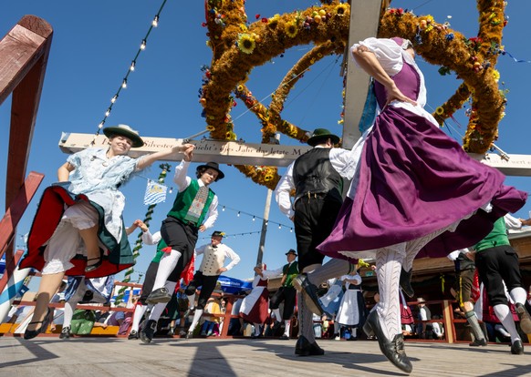 21.09.2024, Bayern, M�nchen: Eine Gruppe des Trachtengau M�nchen f�hrt auf der �Oide Wiesn� unter einer Erntekrone einen Tanz auf. Die Oide Wiesn findet zusammen mit dem Oktoberfest vom 21. September  ...