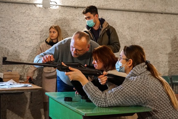 epa09780829 An instructor shows participants how to aim during a training in shooting skills for civilians as part of creating a territorial defense system at the &#039;Oriana&#039; school in Lviv, Uk ...