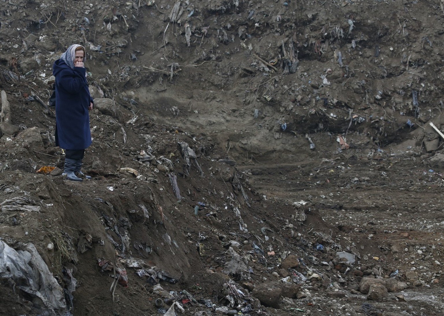 Bosnian woman Nura Begovic, from Srebrenica, reacts as she looks at a mass grave in the village of Kozluk, near eastern town Zvornik, 200 kms east of Sarajevo, Bosnia, on Tuesday, Dec. 15, 2015. The m ...