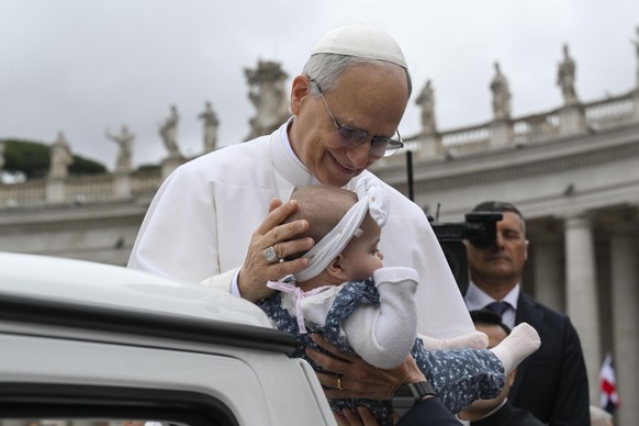 epa12122487 A handout picture provided by the Vatican Media shows Pope Leo XIV blessing a child from the popemobile during the weekly General Audience in St. Peter&#039;s Square, in Vatican City, 21 M ...